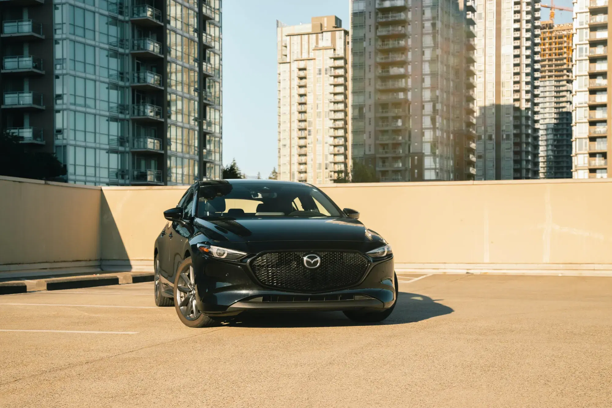 Dark grey Mazda CX-5 SUV at a three-quarter front angle on a solid black background