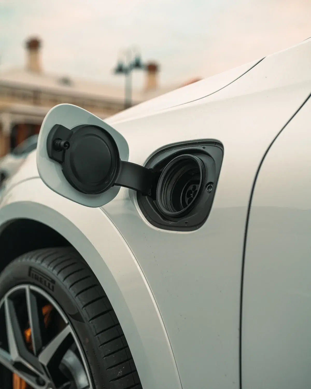 Close-up of a white Polestar electric car with its charging port open and performance wheels